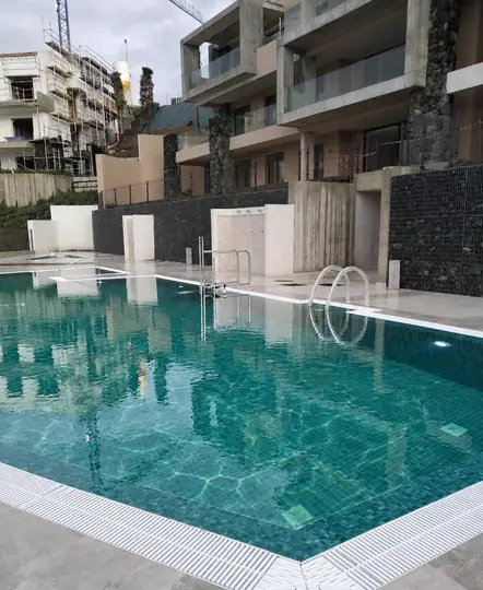 Piscina terminada y en servicio, con la lámina de agua a cota de rebose.