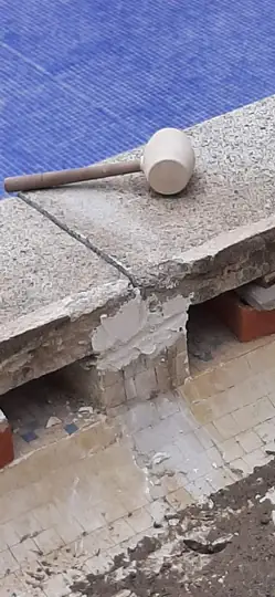 Piedra de coronación recibida sobre calzos durante su recolocación a nivel.