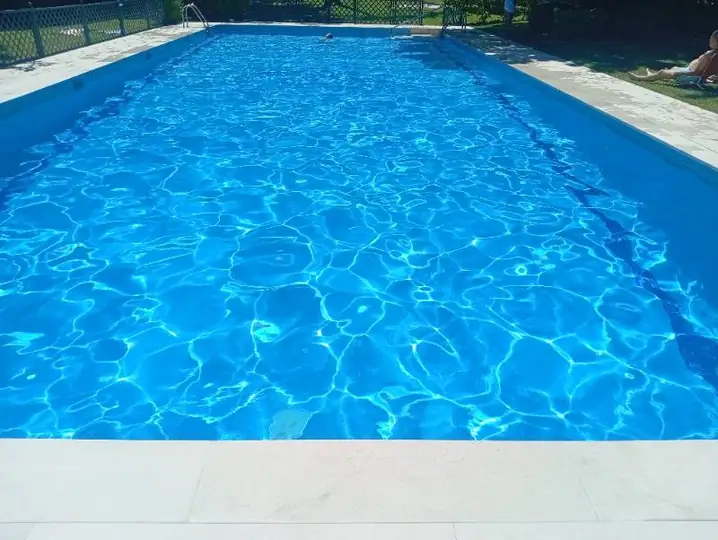 Detalle del borde con coronación y playa antideslizante, agua cristalina en servicio.