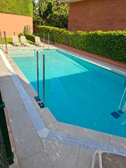 Piscina terminada, con playa de gran formato, rejilla de rebosadero y escaleras inoxidables.