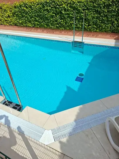 Quiebro del vaso con rejilla de esquina, coronación y escalera, con el agua a nivel de rebose.