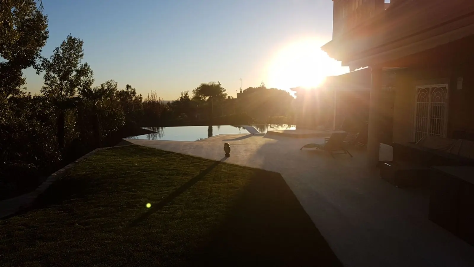 La piscina desbordante al atardecer, con la lámina enrasada con el horizonte