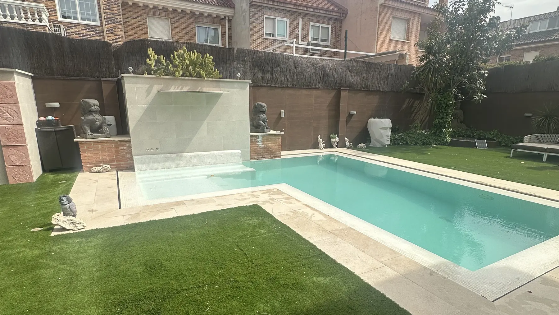 Piscina terminada en Leganés con cascada, leones Fu y césped