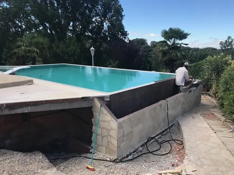 Paramento exterior del canal en ejecución, con el aplacado de piedra natural irregular.