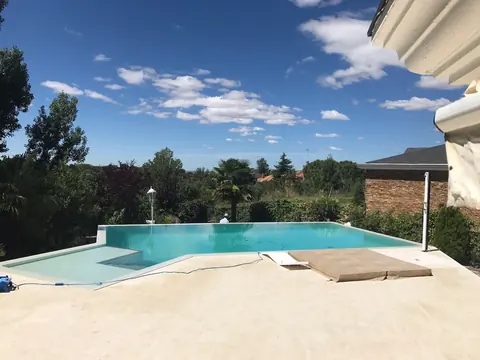 Piscina terminada, con la lámina de agua enrasada con el horizonte.